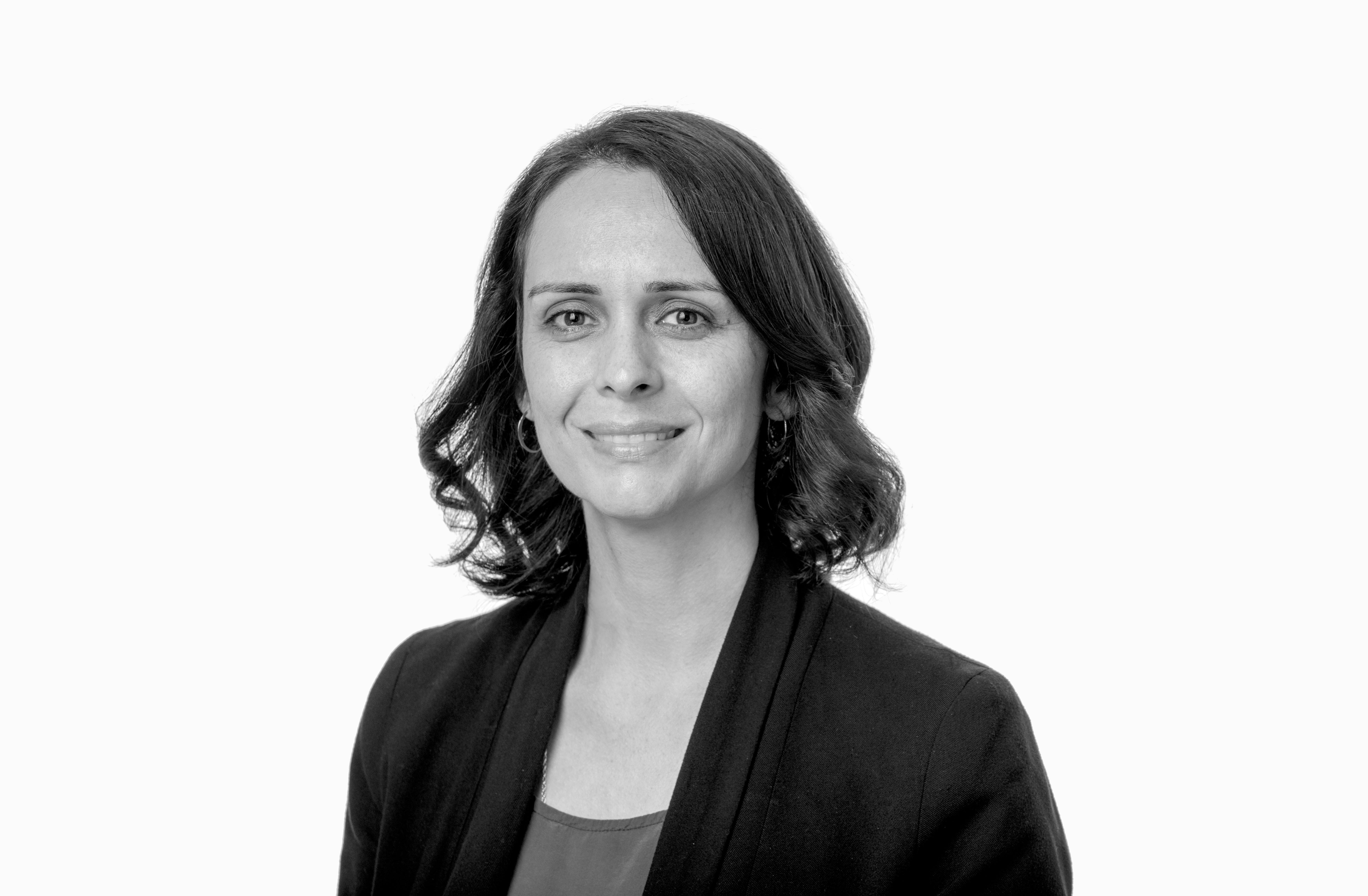 Black and white portrait of Nani Walker, who has shoulder-length hair and is wearing a black blazer.