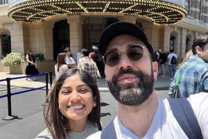Selfie of a man and woman standing in front of a sign reading “Welcome to Cine Gear Expo.”
