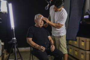 A son dabs gently at the sweat on his father's brow.
