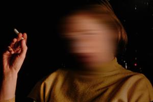 An image of a woman holding a cigarette, but her face is blurred. From Carl Elsaesser’s ‘Home When You Return,’ which is playing at Prismatic Ground. Courtesy of the festival.